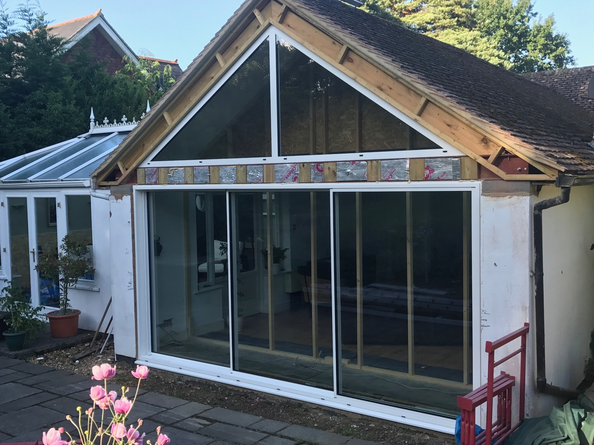 Glass gable installation in progress — full-height glazing